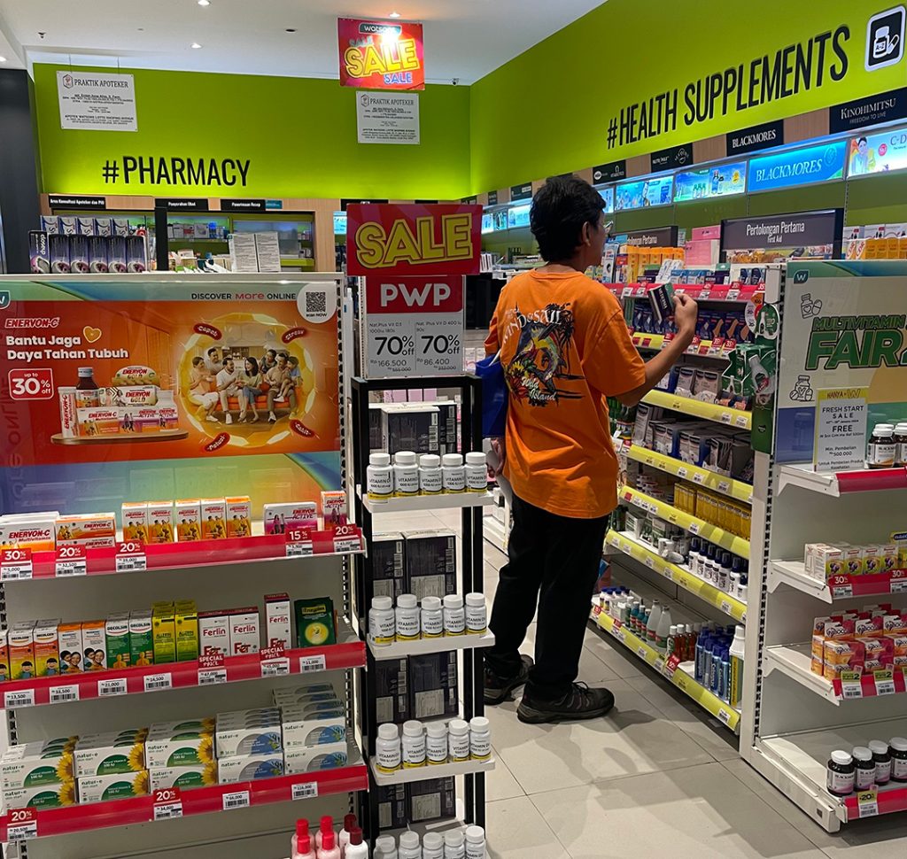 薬局のヘルスケア製品棚を見ている消費者