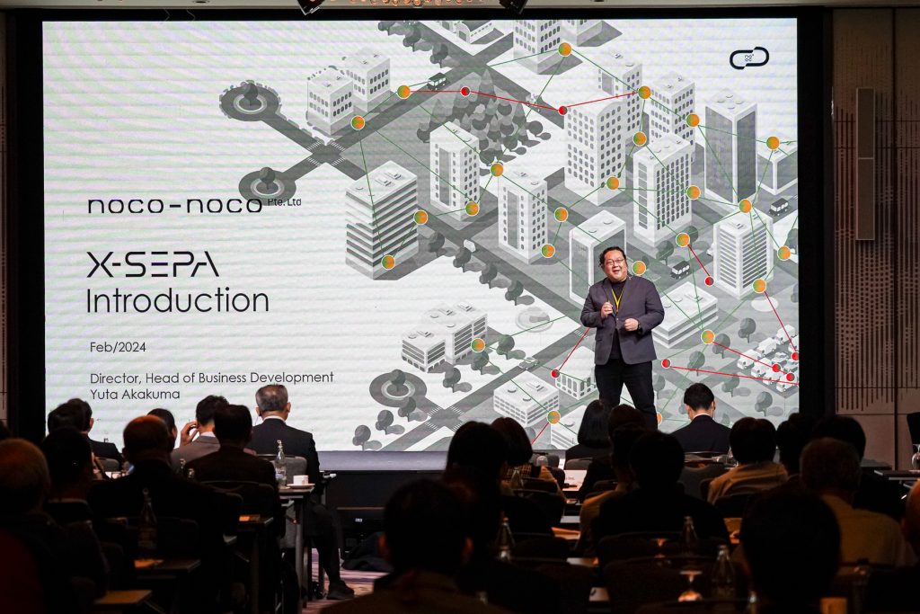 壇上でプレゼンする noco-noco Pte ltd. CEO / MD 赤熊 氏