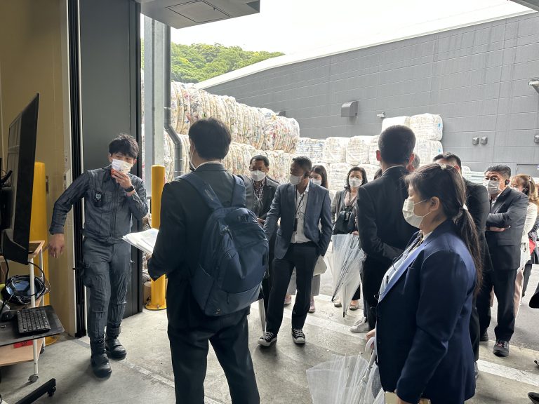 工場内でシステムの説明を聞く参加者たち