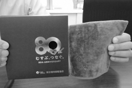 ハラプレックスが手がけた東京信用保証協会のノベルティー(紙パッケージ(左)とホットマンのタオル