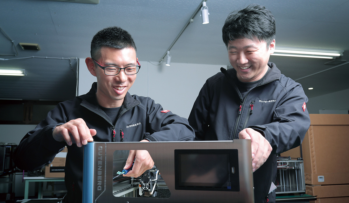 創業者で代表取締役の李氏（写真右）は、3Dプリンター技術を持つ人々を集めて生産体制を確立。さらに、大田区の町工場や投資会社、材料メーカーなどからも協力を得て経営規模を拡大してきた。「人を巻き込み、味方にする行動力」が、李氏の武器の1つだ